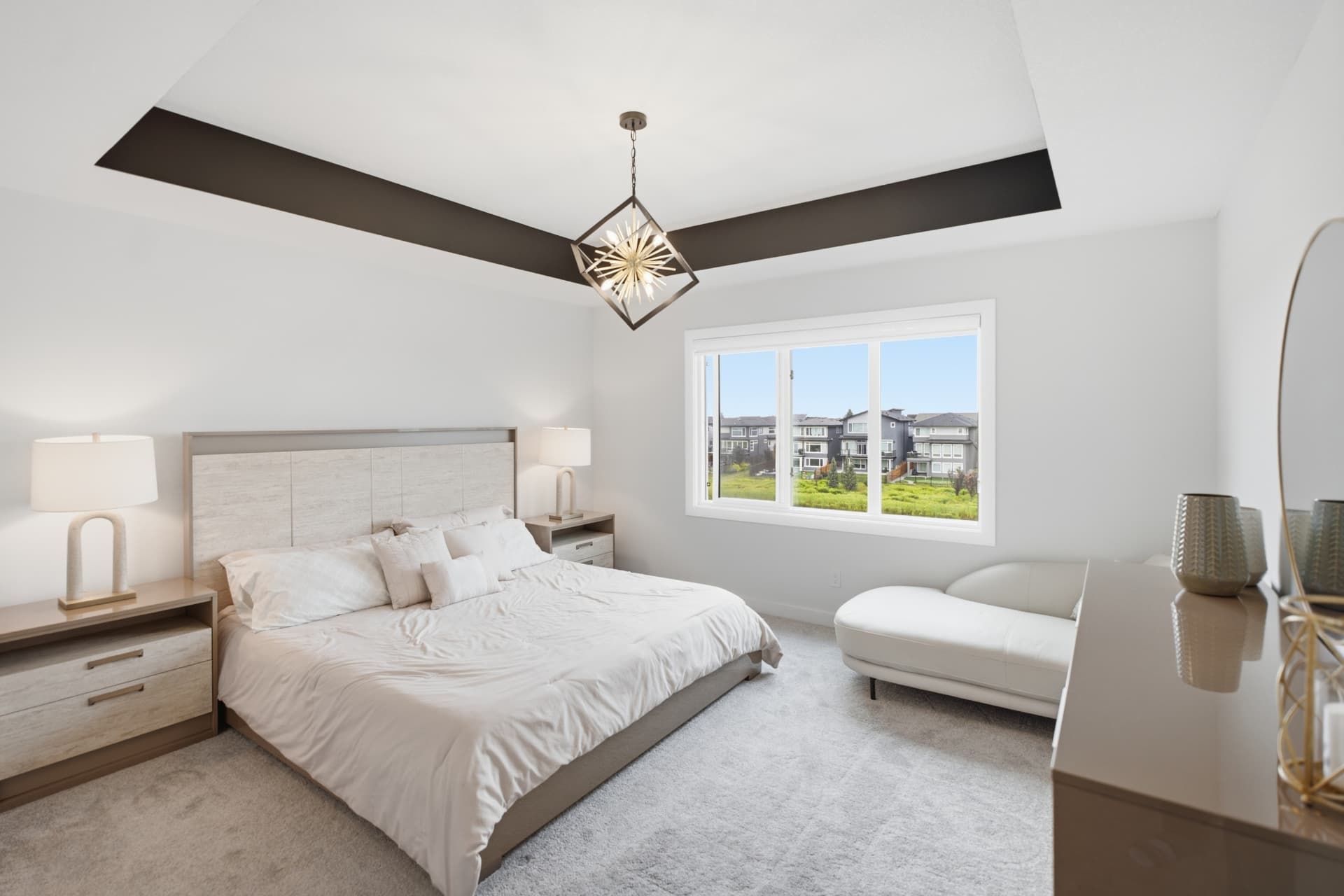 Primary bedroom with tray ceiling and chandelier