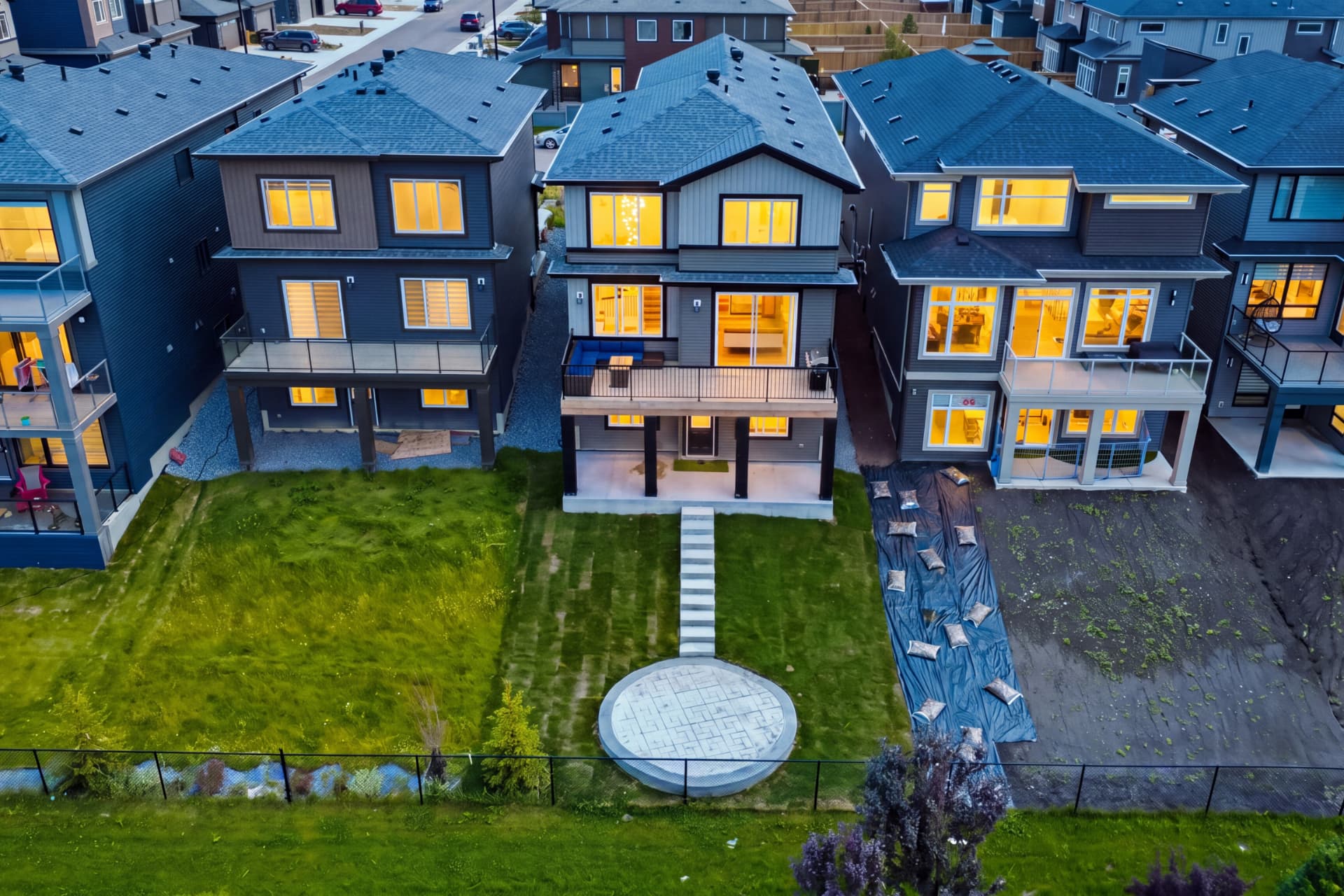 Aerial view of the rear yard and deck at dusk